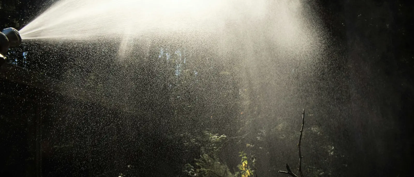 Chorro de niebla a contraluz saliendo de una boquilla
